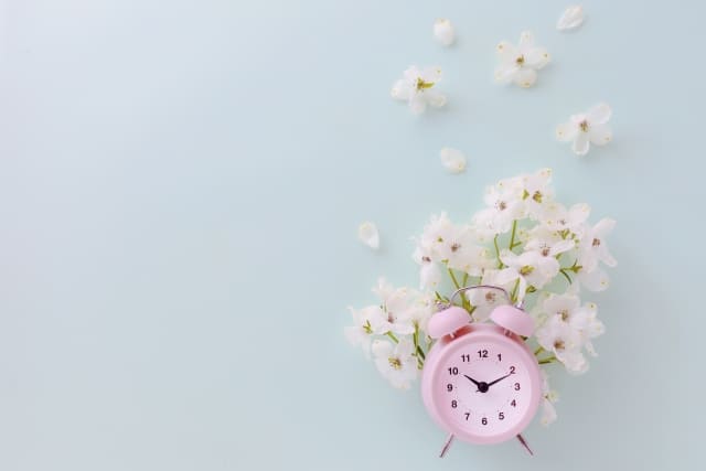 白い花とピンクの時計
